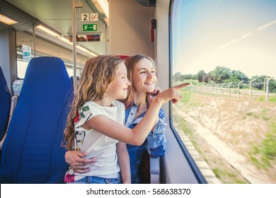 Woman with child traveling by public transport. Family traveling in a train and looking through the window