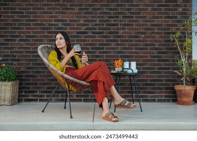 A woman chilling while sitting in a chair holding wine by the pool, exuding tranquility and leisure - Powered by Shutterstock