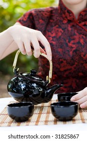 Woman In Chinese Dress Making Chinese Tea