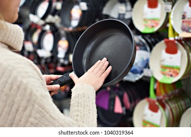 Woman Chooses A Frying Pan In A Crockery Store