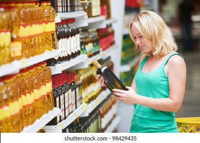 Woman Choosing Bio Food Olive Oil In Grocery Shopping Store