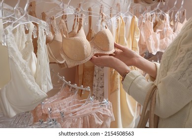 Woman choosing bra in lingerie store, closeup