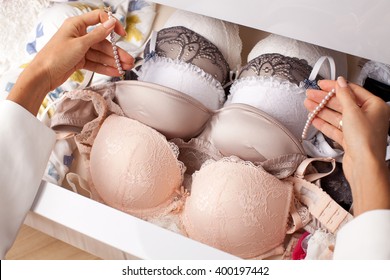 Woman choosing bra. Romantic lingerie. Drawers filled with sexy lace lingerie. Textile, Underwear.