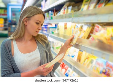 Woman Choosing Cheese In Grocery Store.