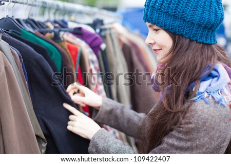 Woman choosing clothes at flea market