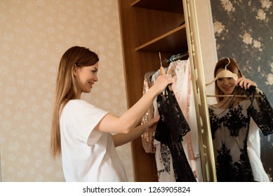 Woman Choosing Clothes In Front Of Full Closet