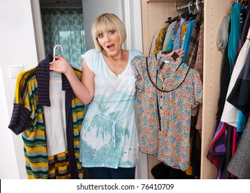 Woman Choosing Clothes In Front Of Full Closet