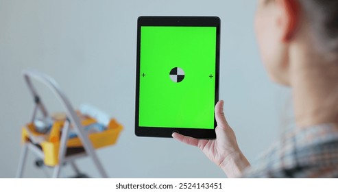 Woman choosing color of walls in new room. TabletPC with green screen. Home, moving, decoration, renovation, and wall painting concept. - Powered by Shutterstock