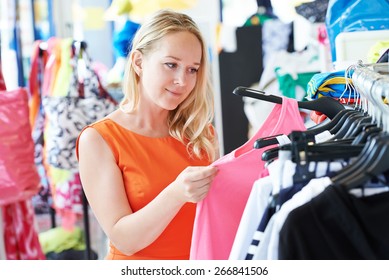 Woman Choosing Dress During Shopping At Garments Apparel Clothing Shop