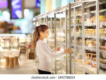 Woman Choosing Frozen Food From A Supermarket Freezer	
