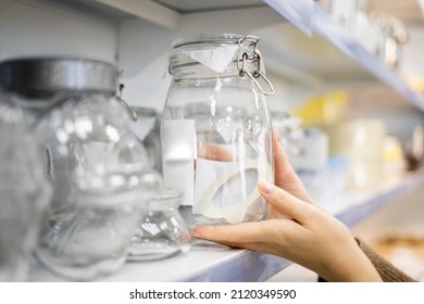 Woman Choosing Glass Jar Container For Food Storage Kitchen Space Organizing Enjoying Shopping At Household Store. Female Taking From Shelf Bottle Box For Keeping Neatly Placing Spices And Dried Herbs