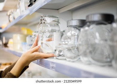 Woman Choosing Glass Jar Container For Food Storage Kitchen Space Organizing Enjoying Shopping At Household Store. Female Taking From Shelf Bottle Box For Keeping Neatly Placing Spices And Dried Herbs