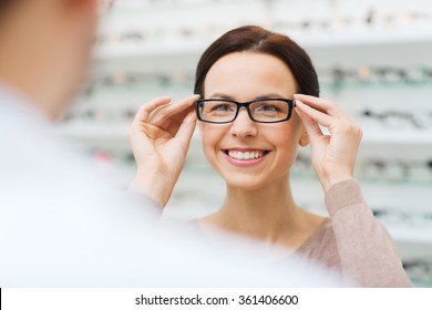 woman choosing glasses at optics store