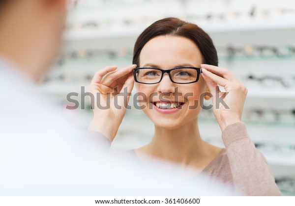 woman choosing glasses\
at optics store