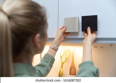 Woman Choosing Kitchen Cabinet Materials From Laminate Samples