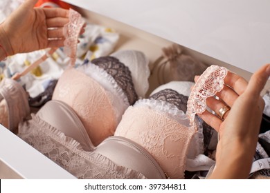 Woman choosing lingerie. Drawers filled with sexy lace lingerie. Textile, Underwear. (soft focus)