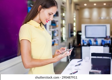 Woman Choosing A New Mobile Phone In A Shop