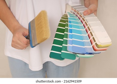 A Woman Choosing A Paint Color From A Sample For A Room