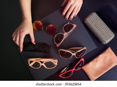 Woman choosing a pair of stylish sunglasses. Toned image