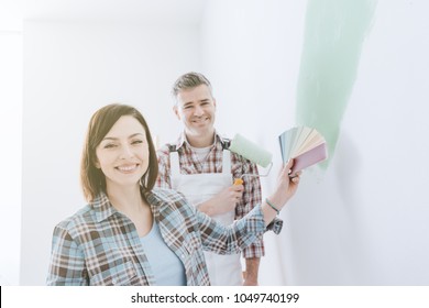 Woman Choosing The Perfect Paint Color For Her Room With A Professional Painter And Decorator, She Is Holding Color Swatches