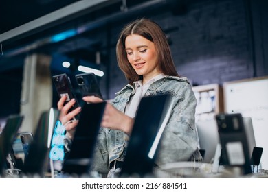 Woman Choosing Phone At Technology Store