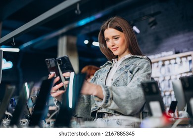 Woman Choosing Phone At Technology Store