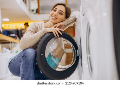 Woman choosing wasing machine at electronics store - Shutterstock ID 2124909104