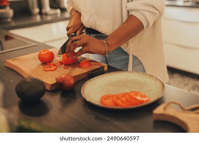 A woman chopping fresh vegetables in the kitchen. The bright kitchen environment and the variety of colorful veggies highlight a healthy and enjoyable cooking process." - Powered by Shutterstock