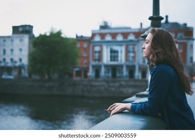 Woman, cigarette and smoking on bridge in city with memory, depressed or sad by river on winter morning. Person, profile and reflection with tobacco product by water with mental health in Denmark - Powered by Shutterstock