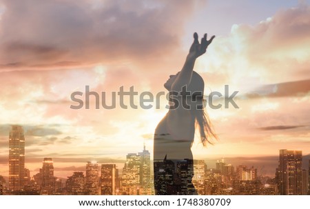 Woman in the city with arms up to the sunset sky feeling happy. Happiness, joy , freedom, and hope concept. Double exposure. 
