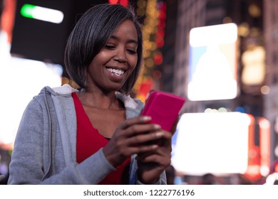 Woman In City At Night Using Cell Phone