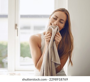 Woman, clean laundry smell and home or cleaning clothes, fabric or blanket with fragrance and happy housekeeping routine. Person, fresh linen and smelling scent of detergent product or soft clothing
