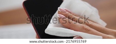 Woman clean mobile phone screen with wet wipe, antibacterial and disinfecting procedure