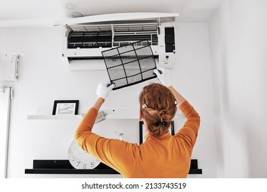 Woman Cleaning Aircon Filters Indoor Unit At Home.