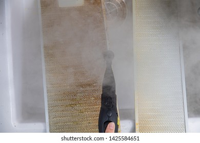 A Woman Cleaning Aluminum Filter For Kitchen Hood By Stream Machine.