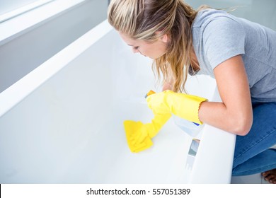 Woman Cleaning The Bath Tub In The Bathroom