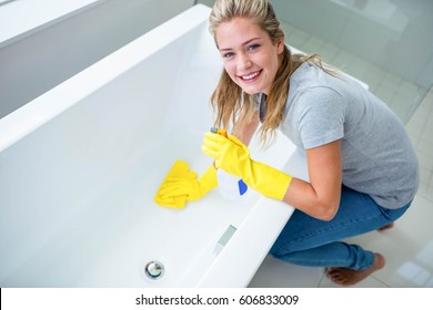 Woman Cleaning The Bath Tub In The Bathroom