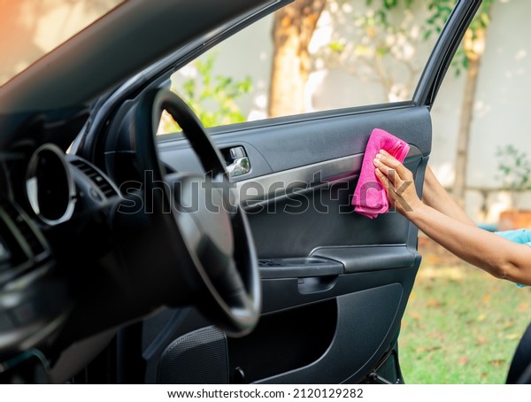 A woman cleaning car interior, car detailing\
concept in front yard.