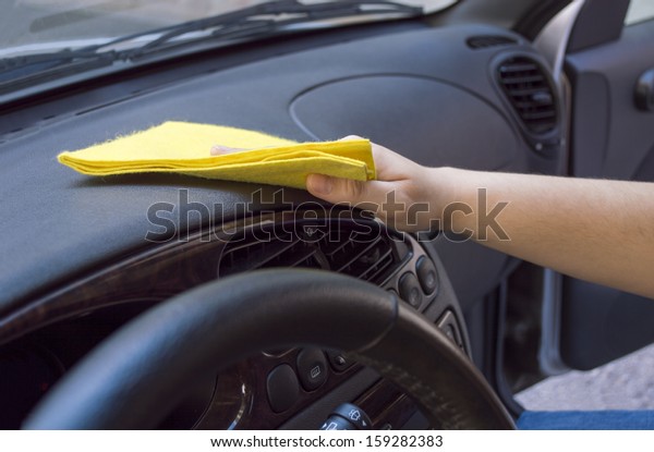 woman\
cleaning the car interior with yellow\
cloth