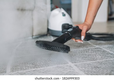 Woman Cleaning The Carpet With A Steam Cleaner