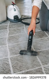 Woman Cleaning The Carpet With A Steam Cleaner