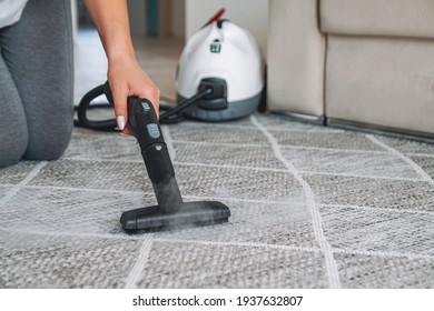 Woman Cleaning The Carpet With A Steam Cleaner