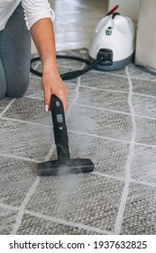 Woman Cleaning The Carpet With A Steam Cleaner