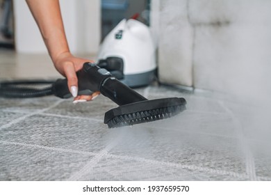 Woman Cleaning The Carpet With A Steam Cleaner