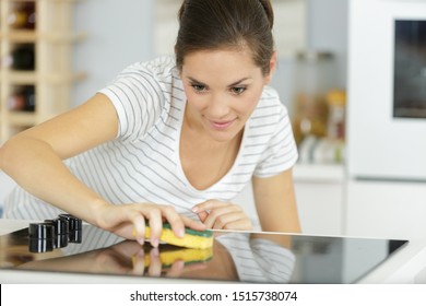 Woman Cleaning Ceramic Hob In The Home