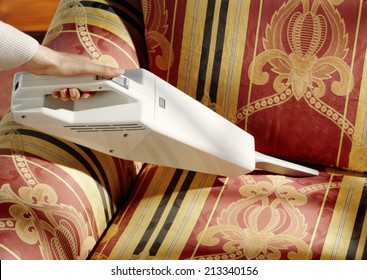 Woman Cleaning Classic Upholstery With A Vacuum Cleaner