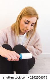 Woman Cleaning Clothes With Sticky Roller From Dust Or Pet Hair. Vertical View