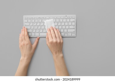 Woman Cleaning Computer Keyboard On Light Background