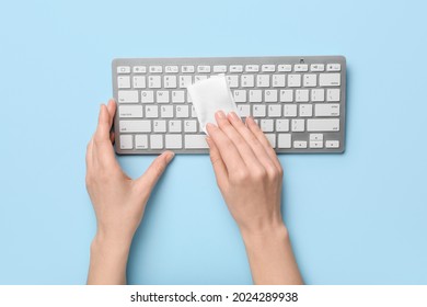 Woman Cleaning Computer Keyboard On Color Background