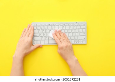 Woman Cleaning Computer Keyboard On Color Background